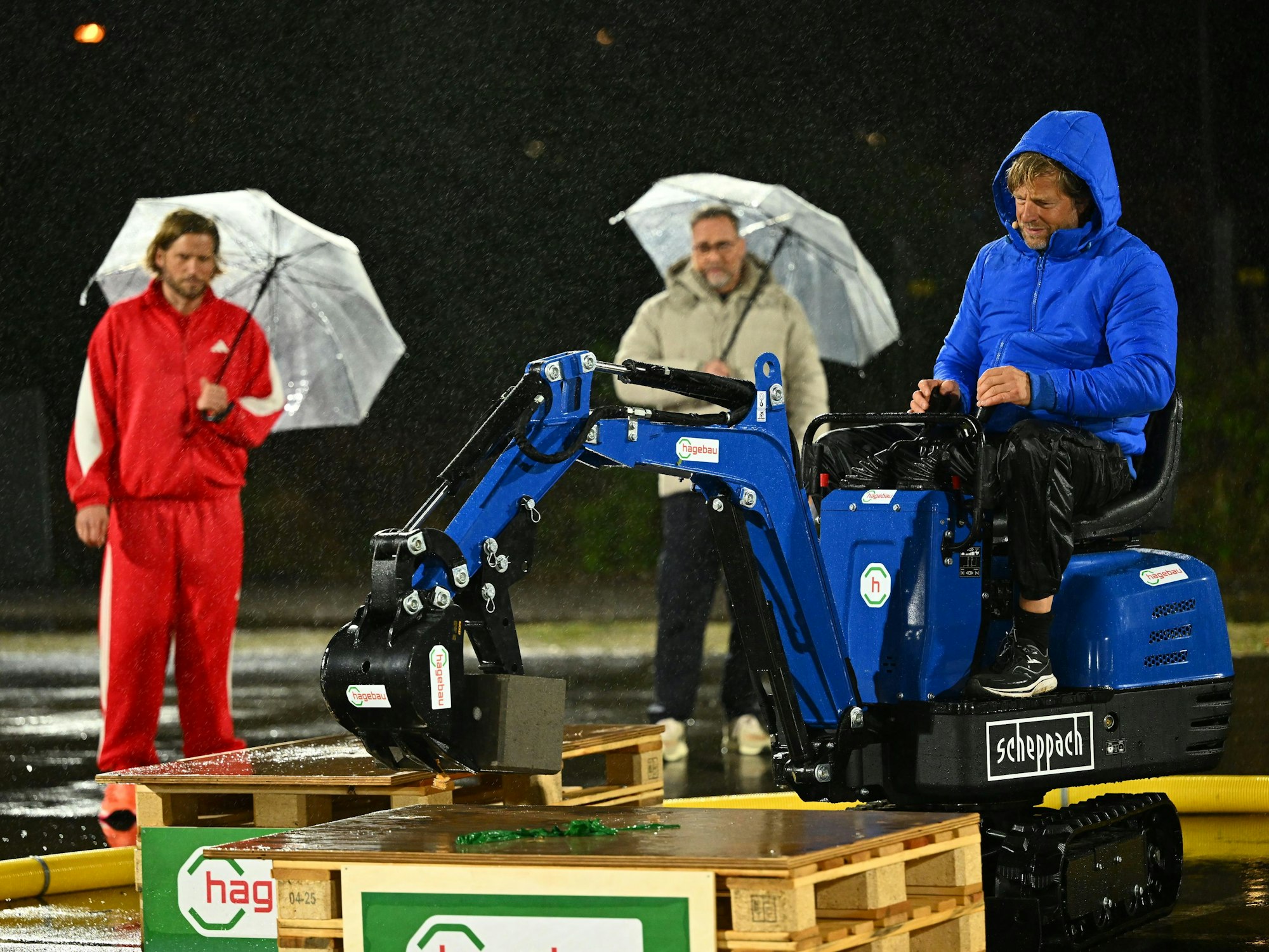 Henning Baum baggert bei Schlag den Star, während Kontrahent Sebastian Ströbel und Moderator Matthias Opdenhövel zuschauen.