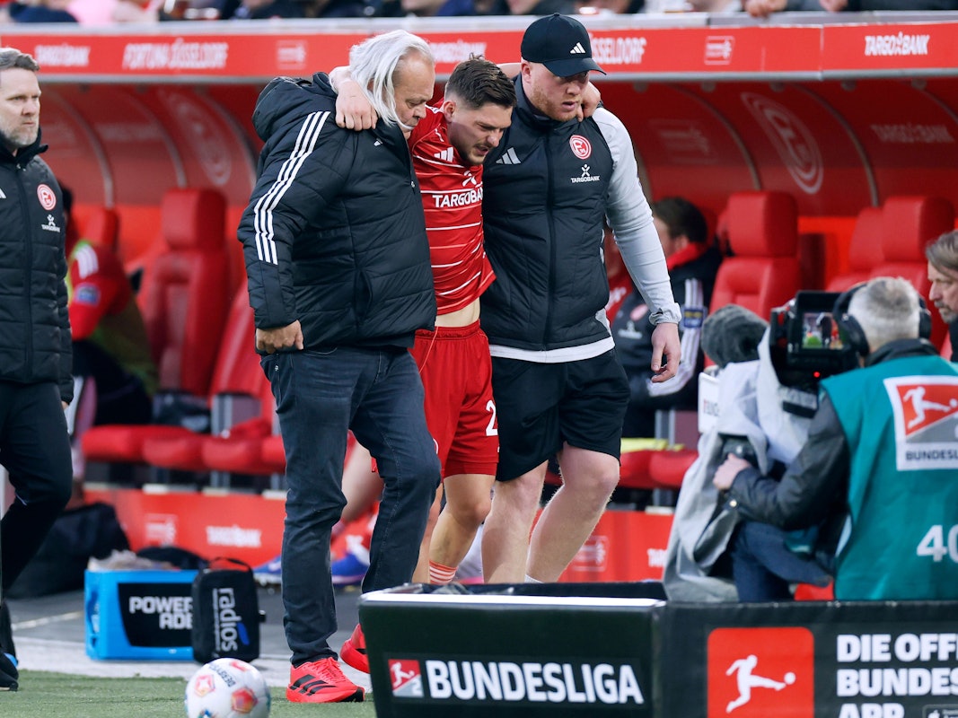 Florent Muslija wird von zwei Personen gestützt und humpelt vom Feld.