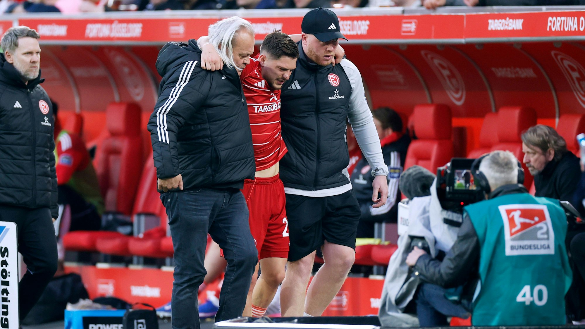 Florent Muslija wird von zwei Personen gestützt und humpelt vom Feld.