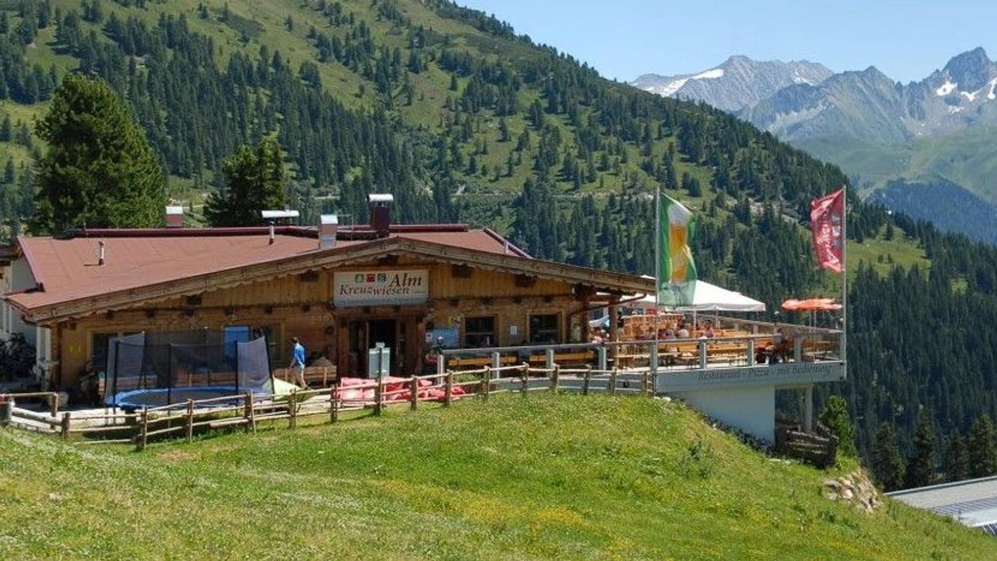 Eine Almhütte mit großer Sonnenterrasse und Blick auf die Berge