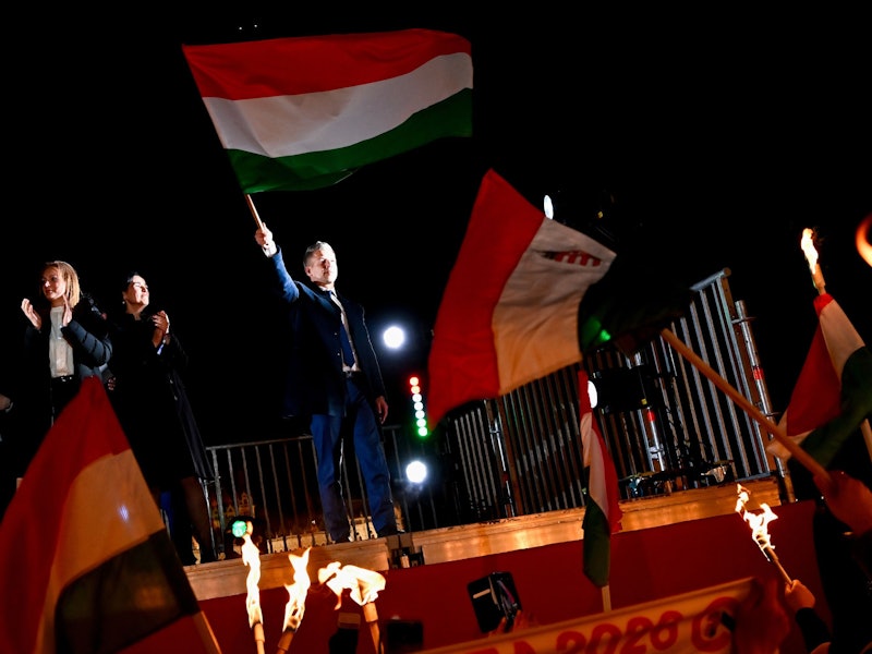 Peter Magyar, Vorsitzender der Oppositionspartei Tisza, schwenkt die ungarische Flagge nach der Bekanntgabe der Teilergebnisse der Parlamentswahl.