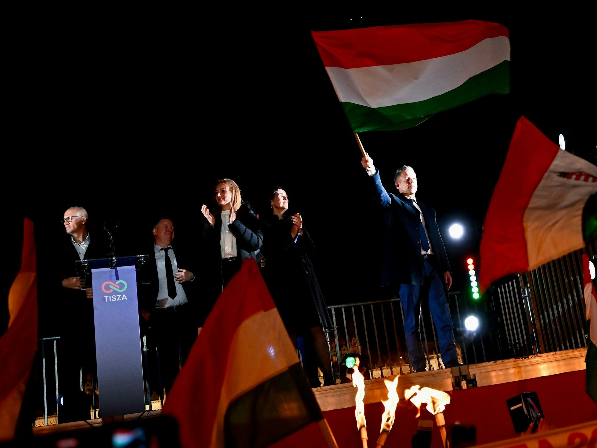 Peter Magyar, Vorsitzender der Oppositionspartei Tisza, schwenkt die ungarische Flagge nach der Bekanntgabe der Teilergebnisse der Parlamentswahl.