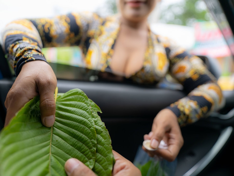 Personen tauschen Geld für Kratom-Blätter