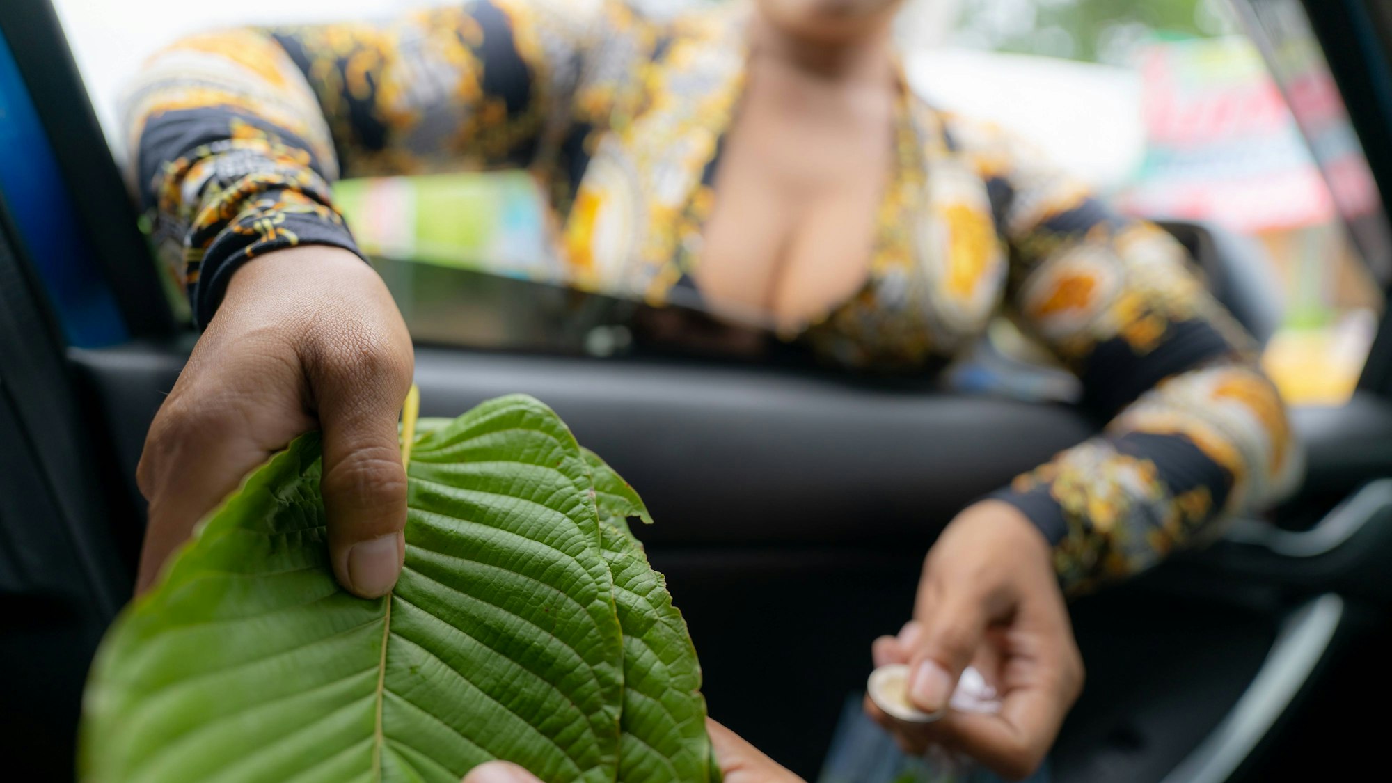 Personen tauschen Geld für Kratom-Blätter