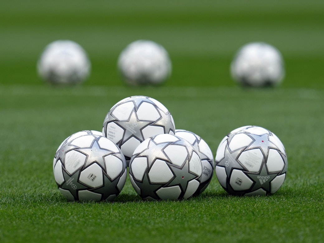 Fußbälle liegen auf dem Rasen.