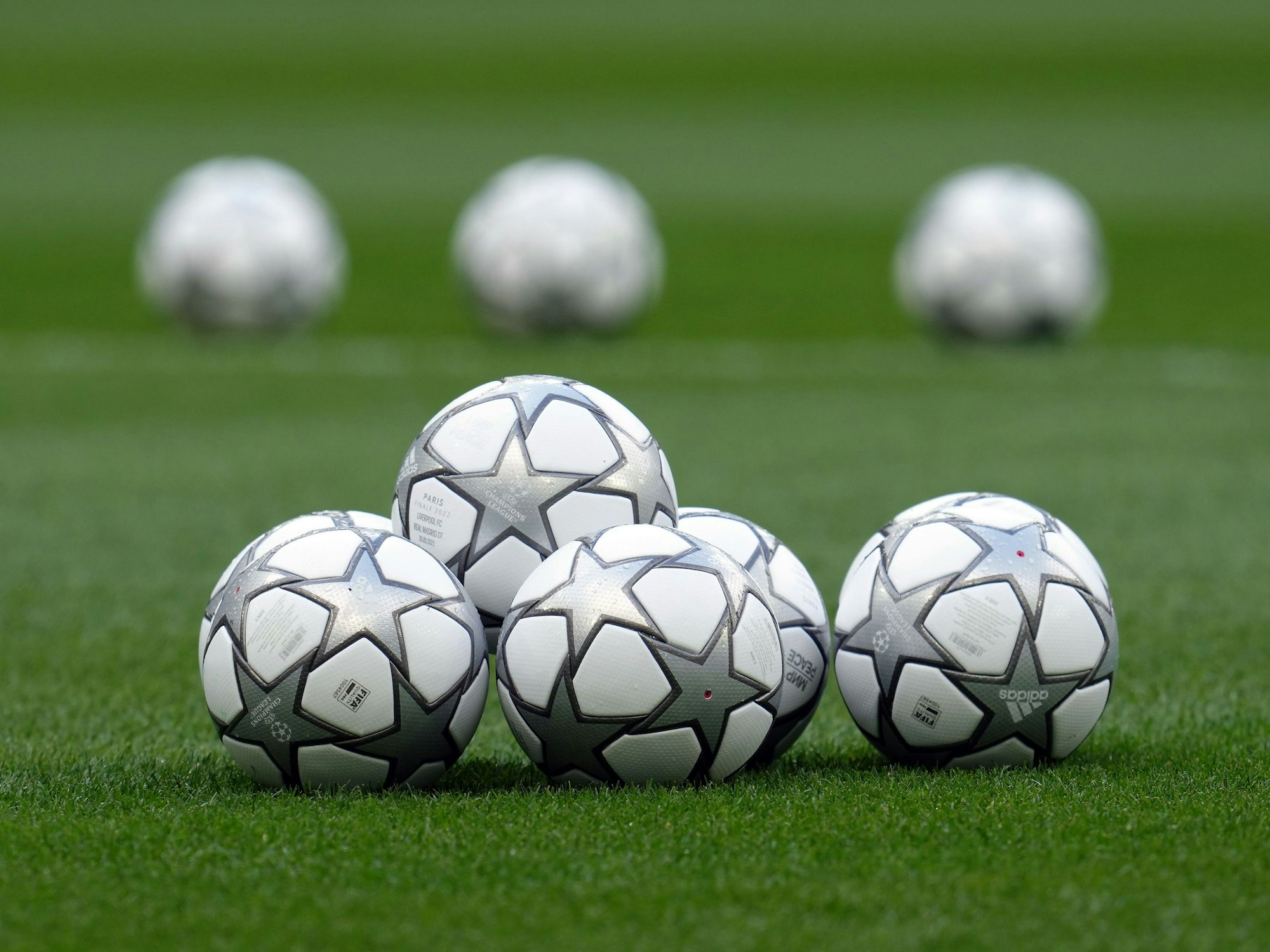 Fußbälle liegen auf dem Rasen.
