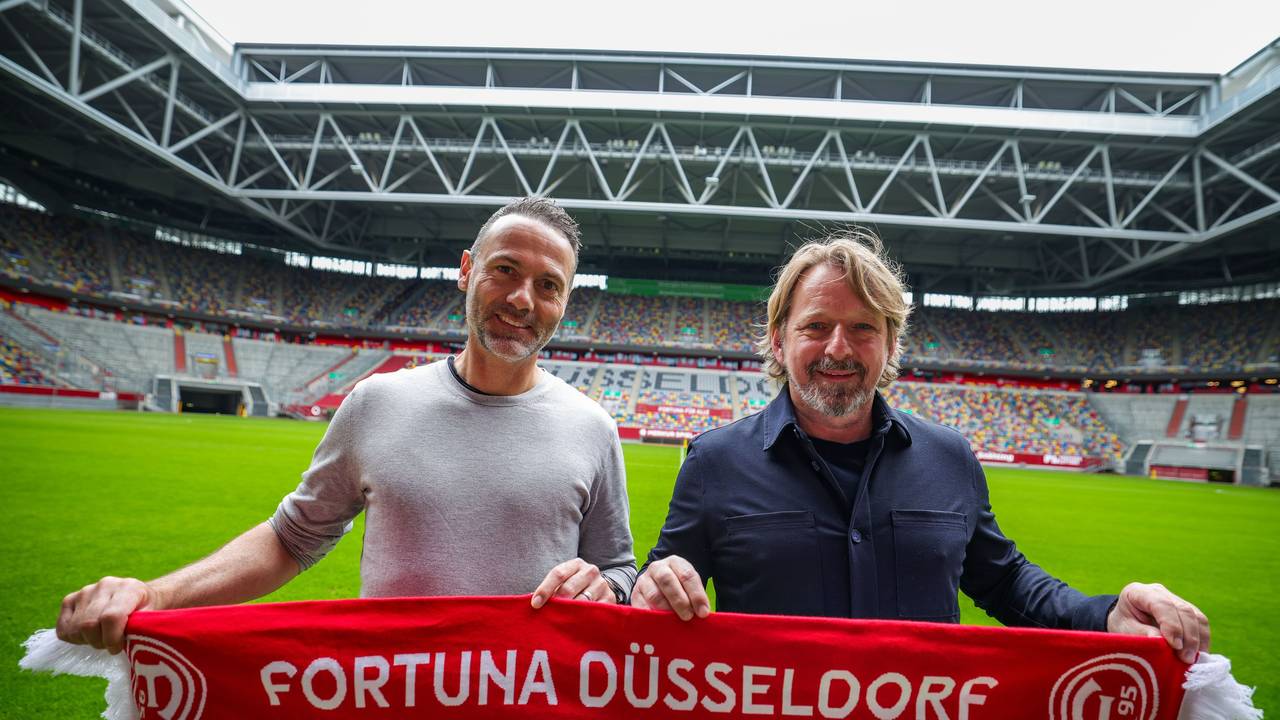 Alexander Ende und Sven Mislintat posieren mit Fortuna-Düsseldorf-Schal in der Merkur-Spiel-Arena.
