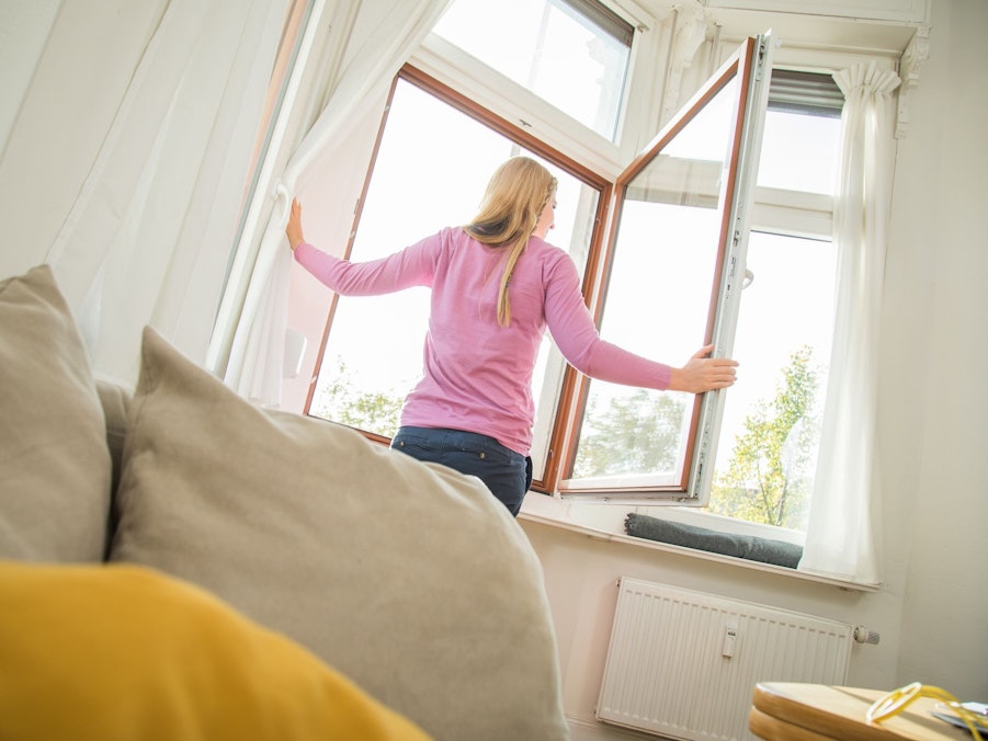 Eine Frau öffnet ein Fenster