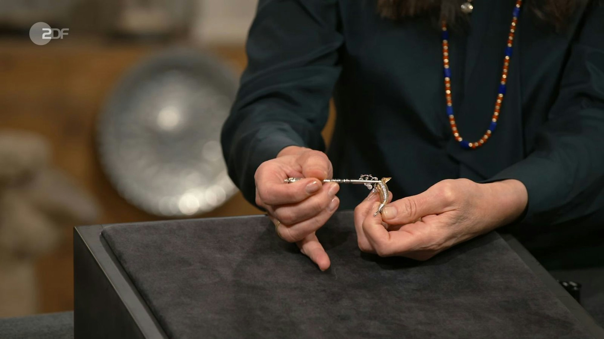 „Ne, hör auf! Das wackelt ja!“, begeisterte sich Lichter für eine mit Diamanten besetzte Brosche. Aufgrund der Beweglichkeit der Steine nannte man solchen Schmuck gern „Zitterbrosche“, wusste Heide Rezepa-Zabel. Die Expertin nannte 1.000 Euro. Lisa Nüdling bezahlte 750. (Bild: ZDF)