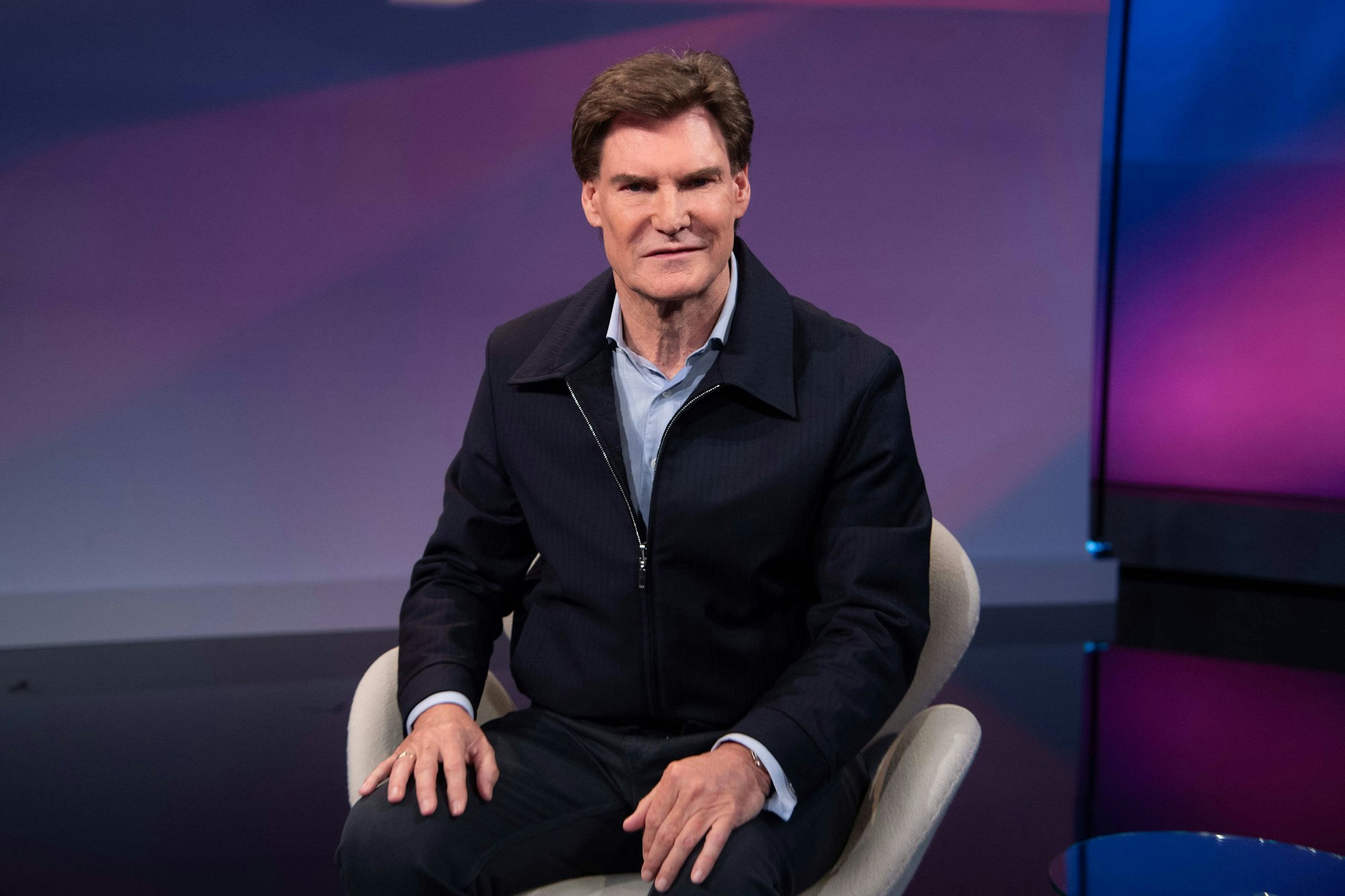 Carsten Maschmeyer sitzt, trägt Jacke und Hemd.