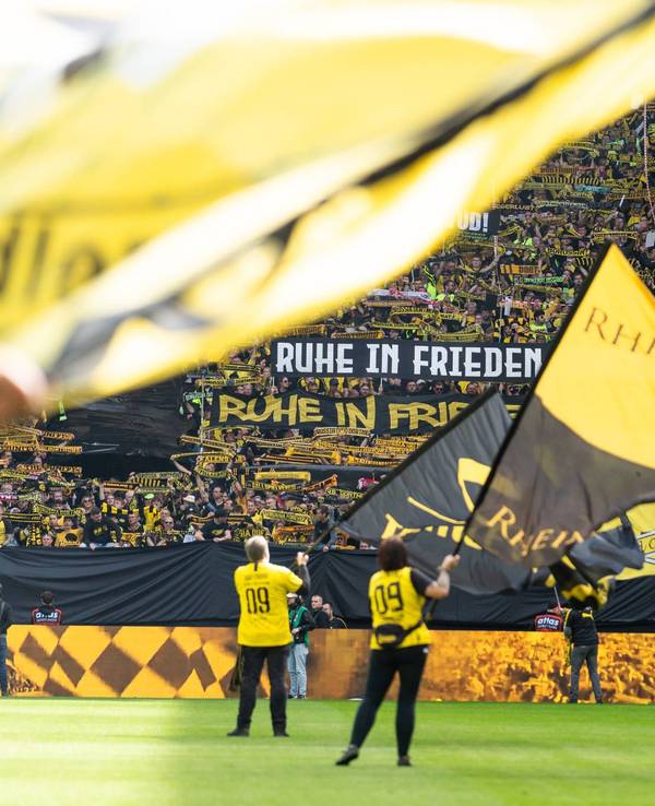 Vor einem Spiel von Borussia Dortmund werden riesige Fahnen auf dem Platz geschwenkt.