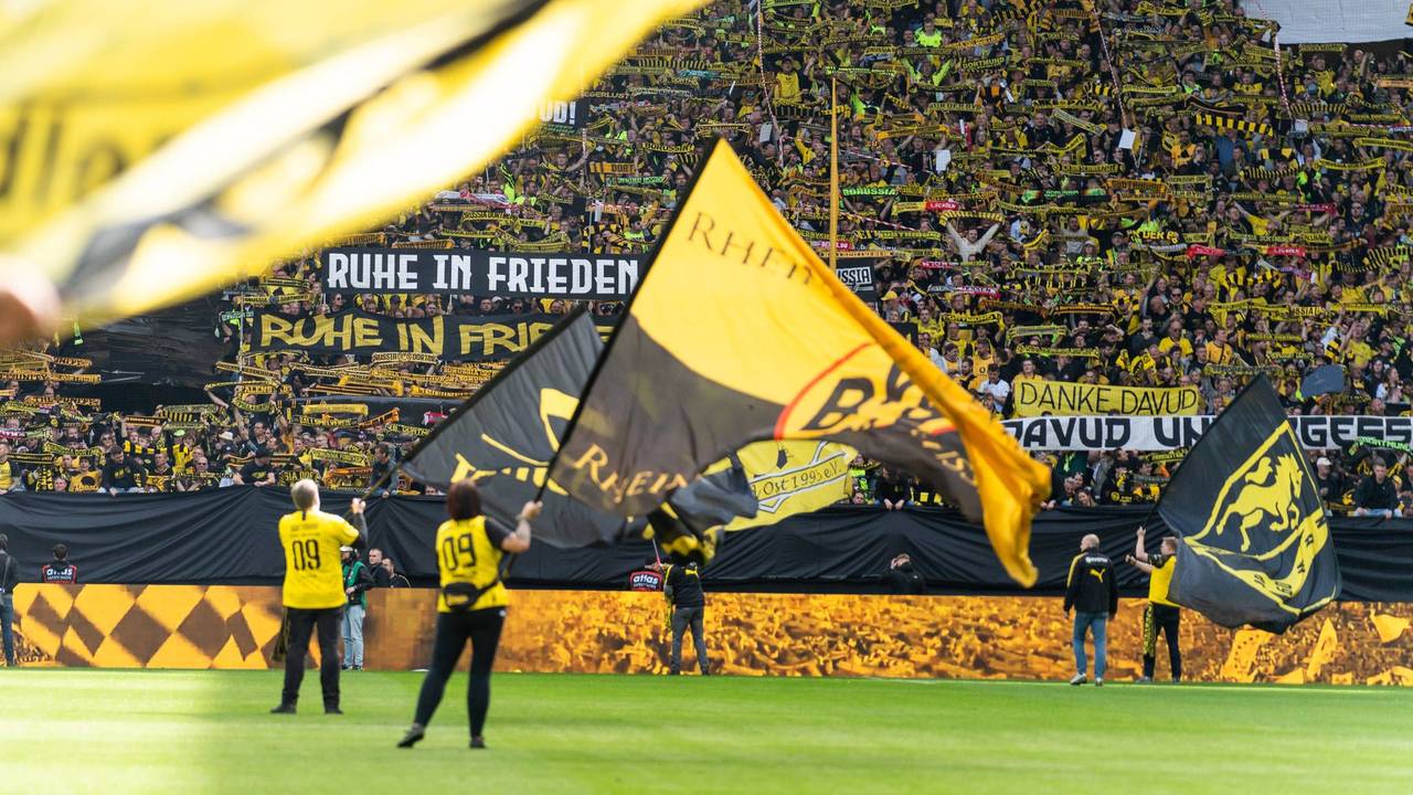 Vor einem Spiel von Borussia Dortmund werden riesige Fahnen auf dem Platz geschwenkt.