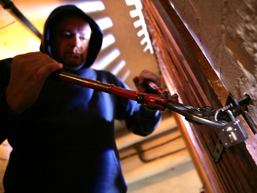 Einbrecher versucht eine Tür aufzubrechen.