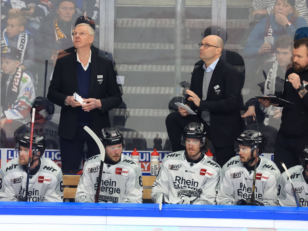 Haie-Cheftrainer Kari Jalonen steht bei seinen Spielern am Rande der Eisfläche.