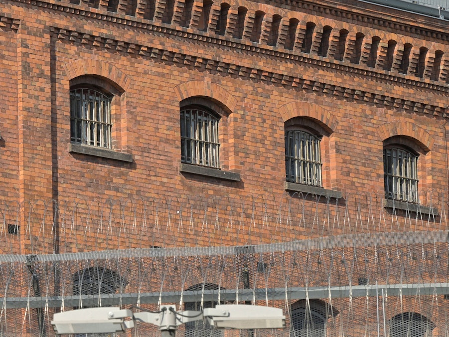 Gefängnisgebäude mit Gitterfenstern und Sicherheitszaun