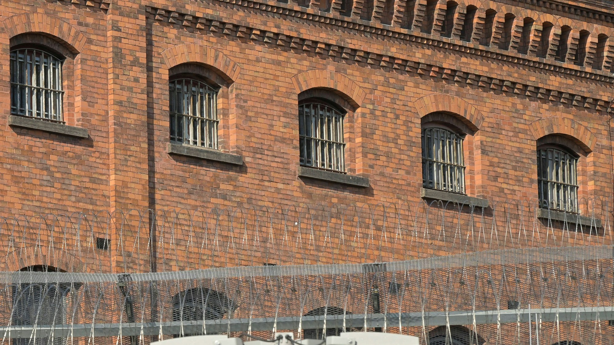 Gefängnisgebäude mit Gitterfenstern und Sicherheitszaun