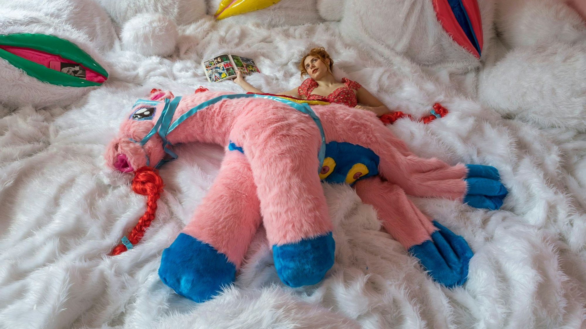 Ein Plüschpony liegt auf einer Frau