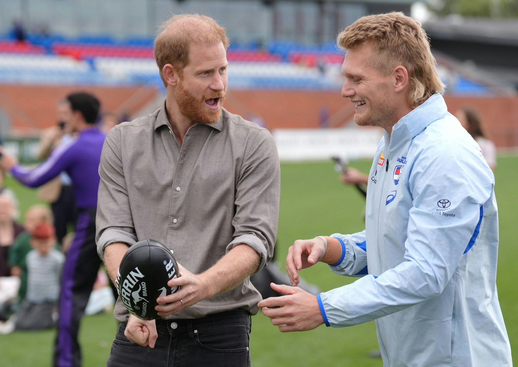 Prinz Harry schlägt einen Football während eines Australian Rules Football-Trainings der Western Bulldogs in Footscray, einem Vorort von Melbourne.