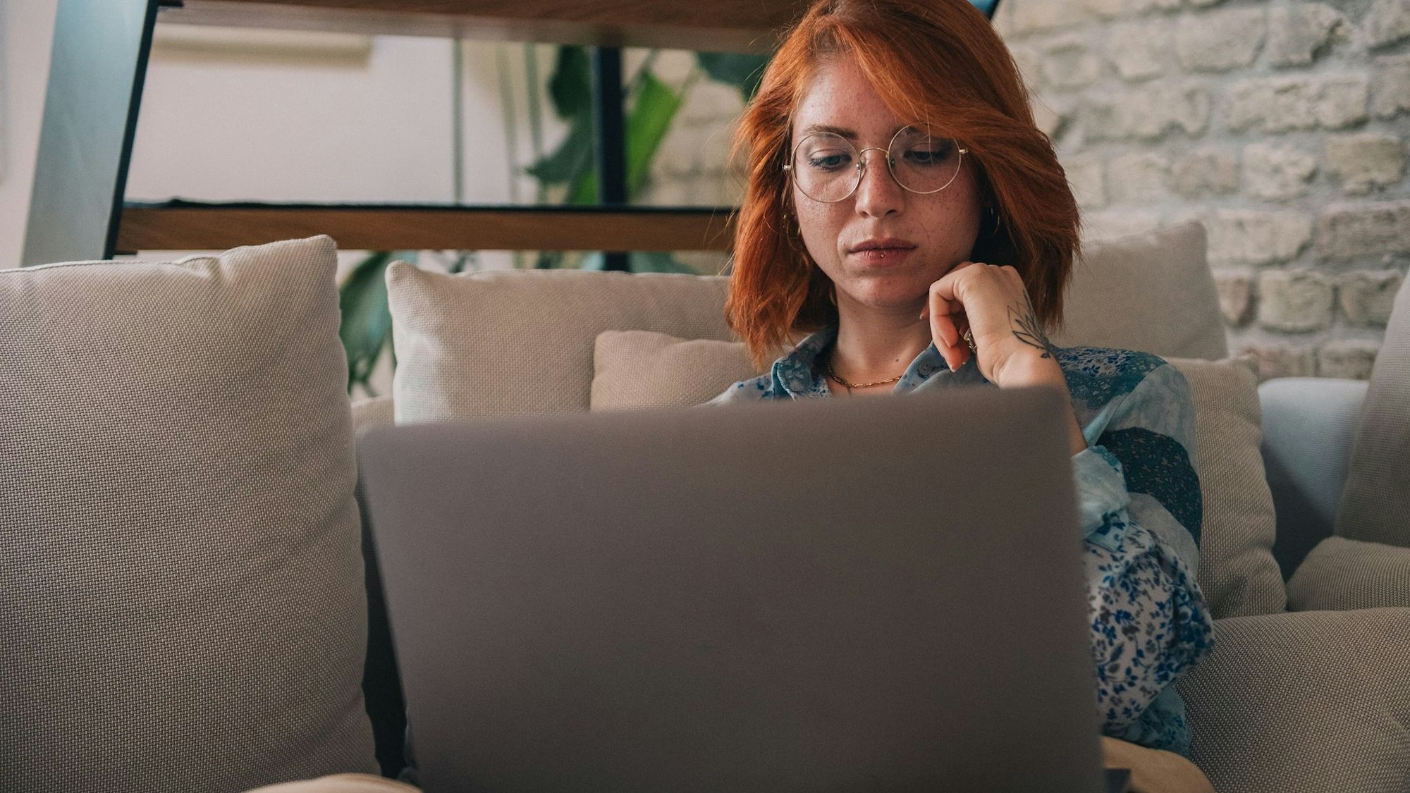 Frau schaut nachdenklich auf einen Laptop