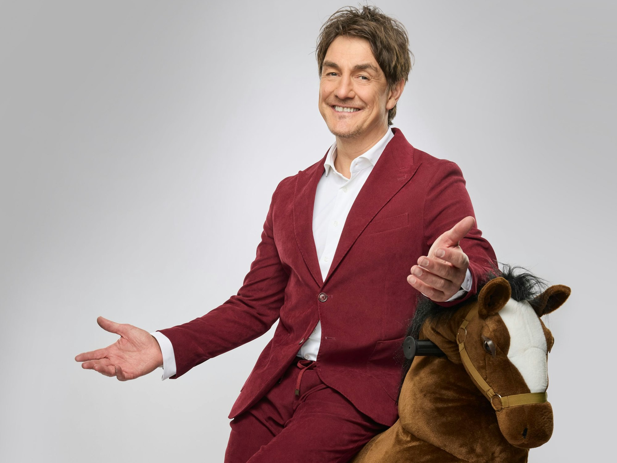 Matze Knop sitzt auf einem Plüschpferd.