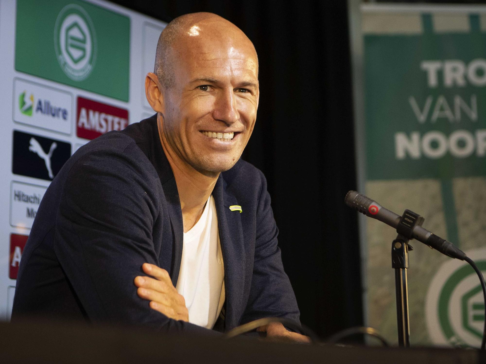 Der frühere Bayern-Star Arjen Robben sitzt an einem Mikrofon.