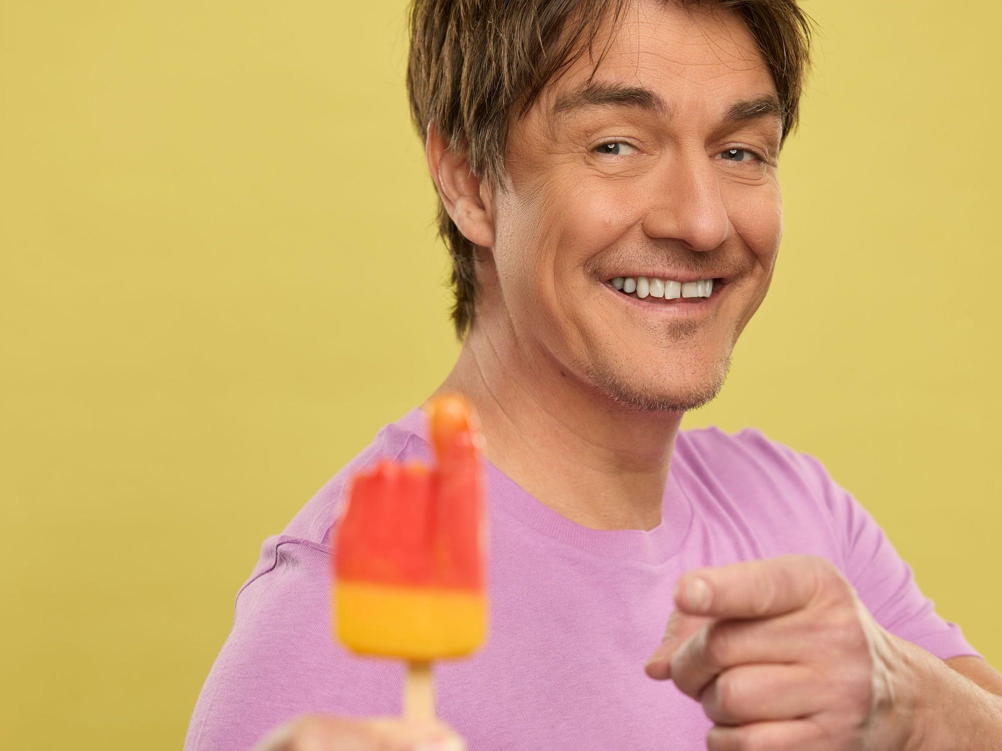 Matze Knop hält das Eis Flutschfinger in der Hand.