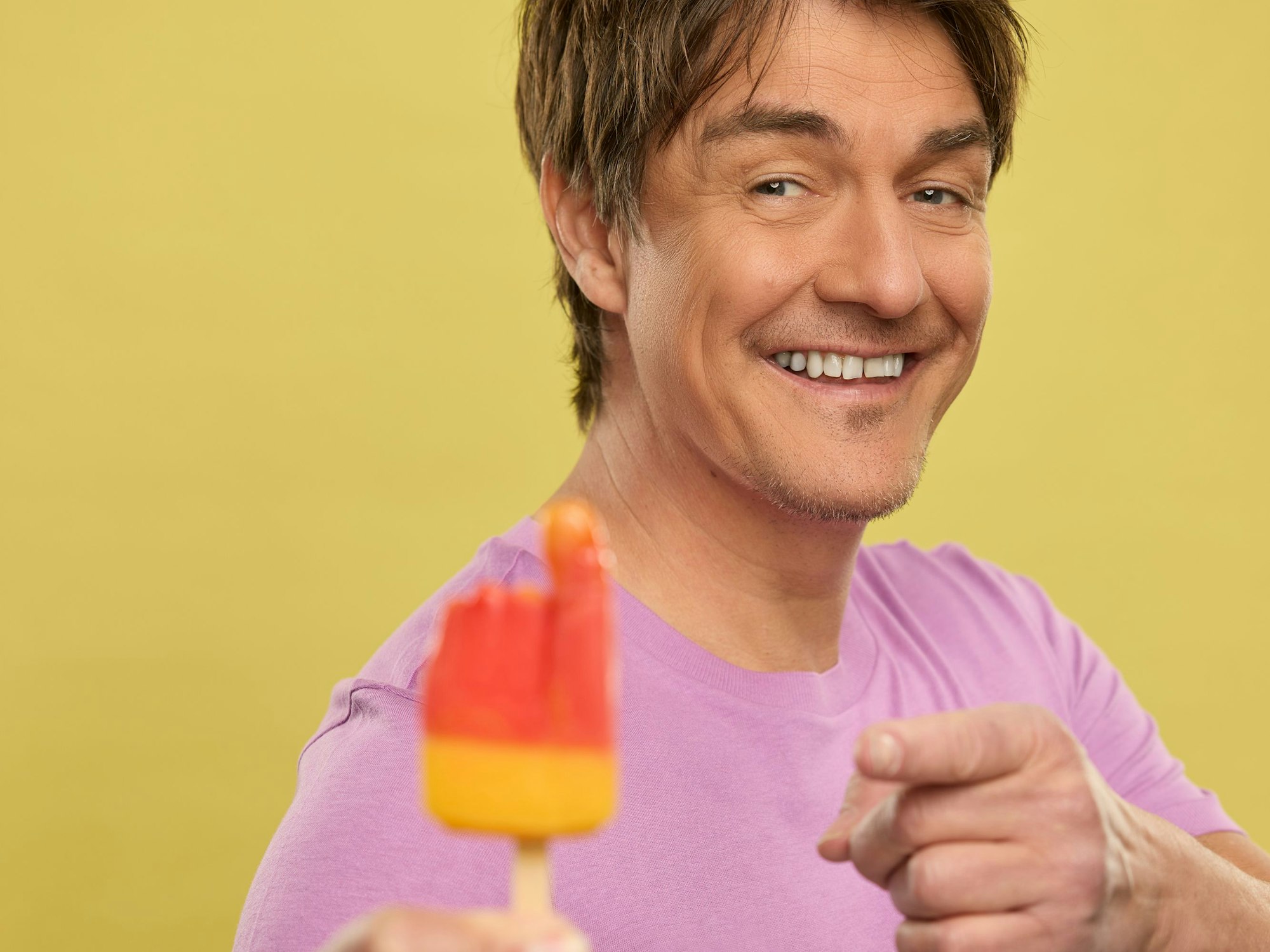 Matze Knop hält das Eis Flutschfinger in der Hand.