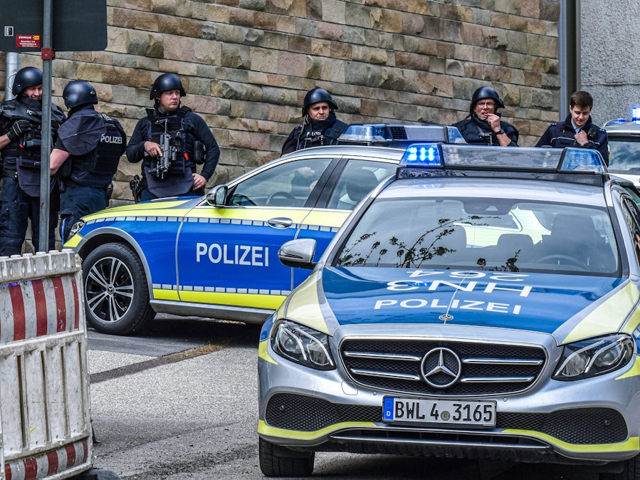 Einsatzkräfte der Polizei und Polizeifahrzeuge mit Blaulicht