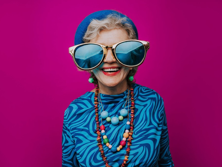 Eine glückliche Seniorin mit übergroßer Sonnenbrille