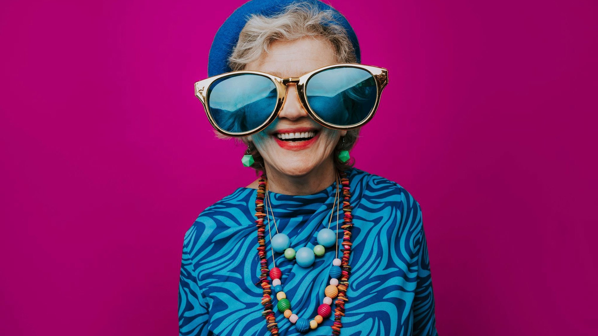 Eine glückliche Seniorin mit übergroßer Sonnenbrille