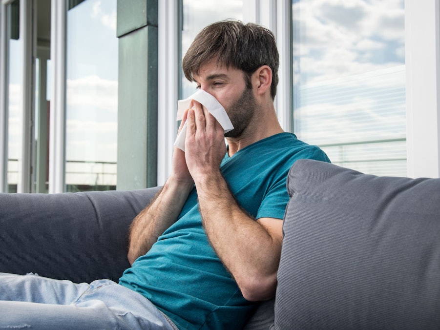 Ein Mann putzt sich die Nase