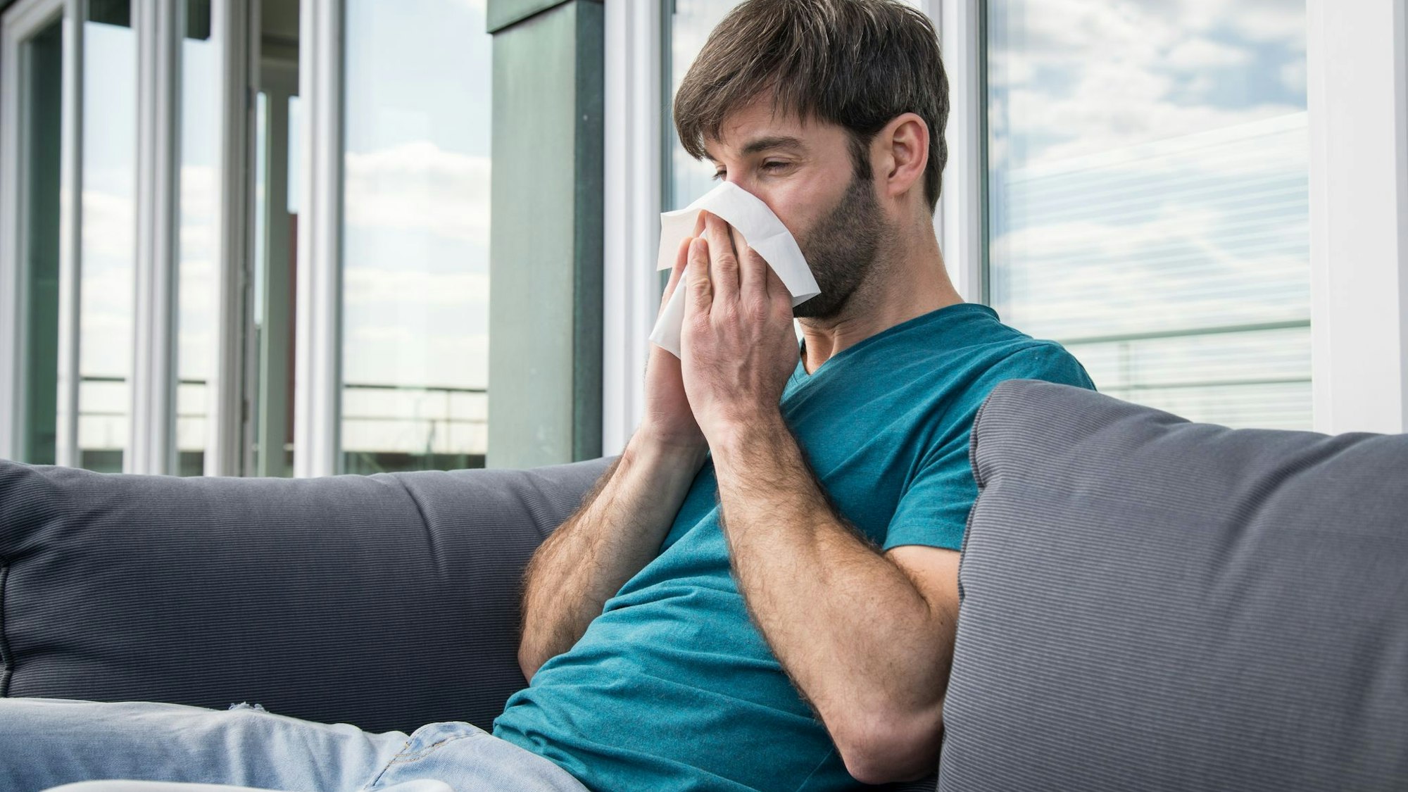 Ein Mann putzt sich die Nase