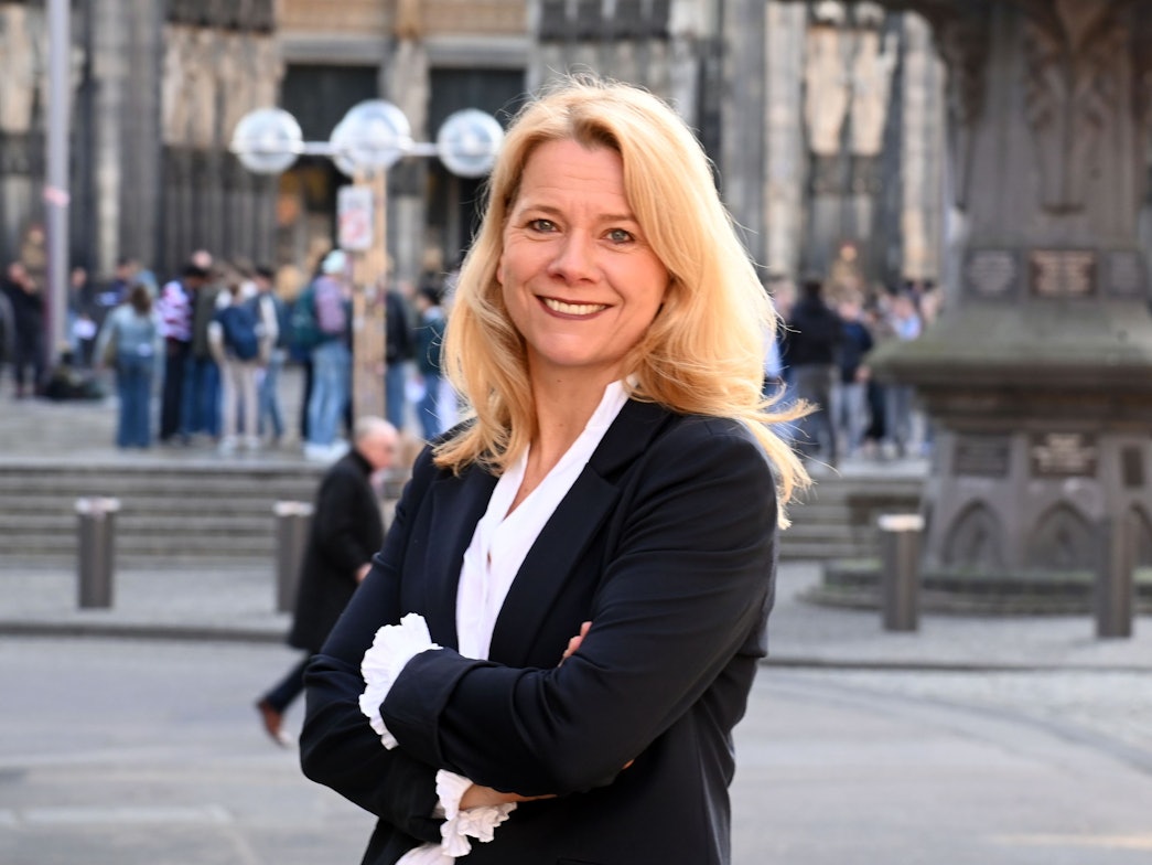 Stephanie Kleine Klausing steht mit verschränkten Armen vor dem Kölner Dom.