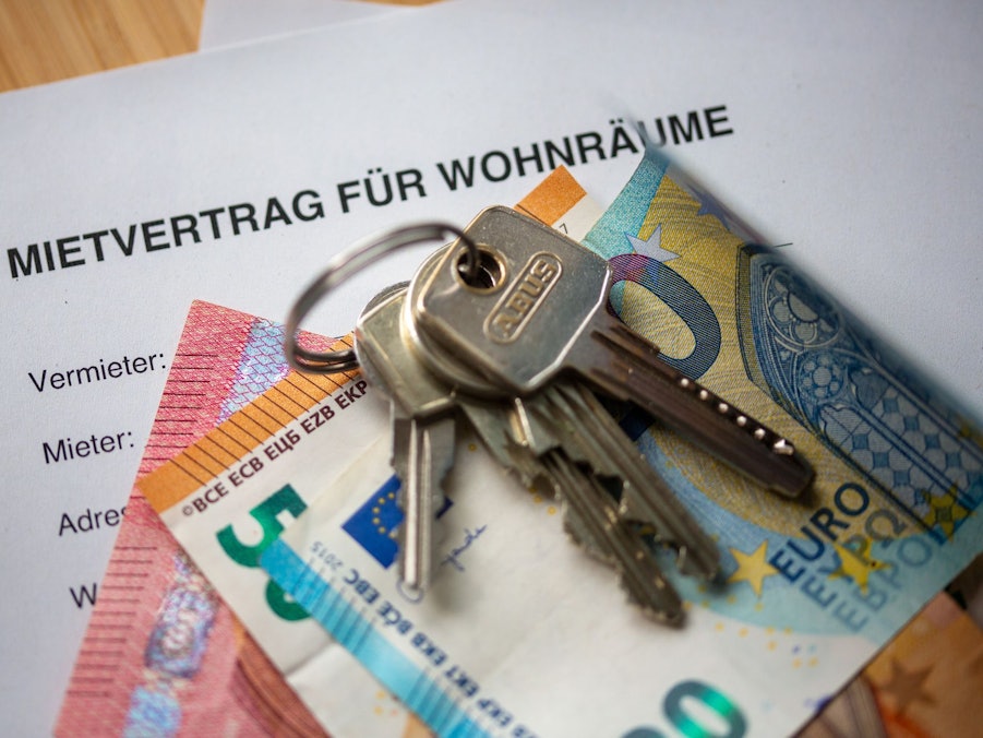 Mietvertrag, Geldscheine und Hausschlüssel auf einem Tisch