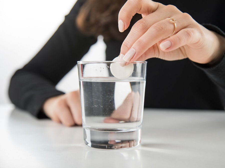 Brausetablette wird in ein Glas Wasser gegeben