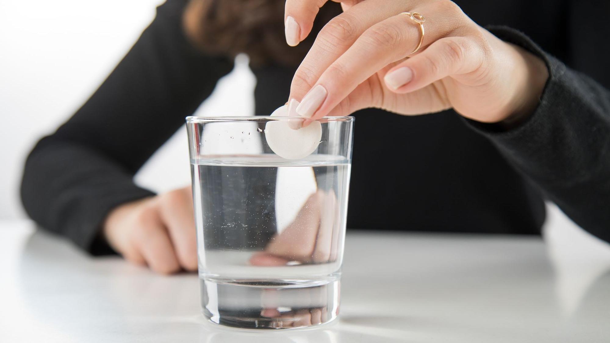 Brausetablette wird in ein Glas Wasser gegeben