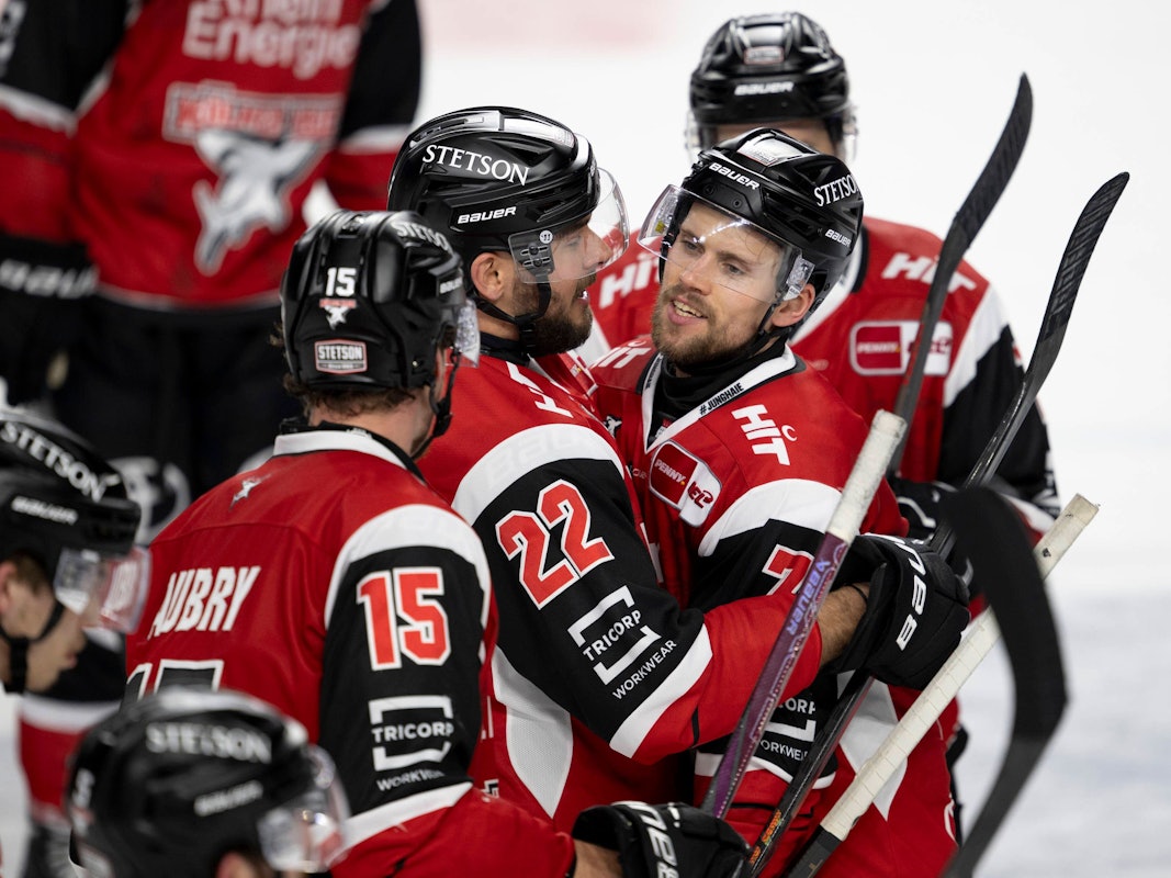 Maximilian Glötzl gratuliert Dominik Bokk auf dem Eis, Louis-Marc Aubry kommt dazu.