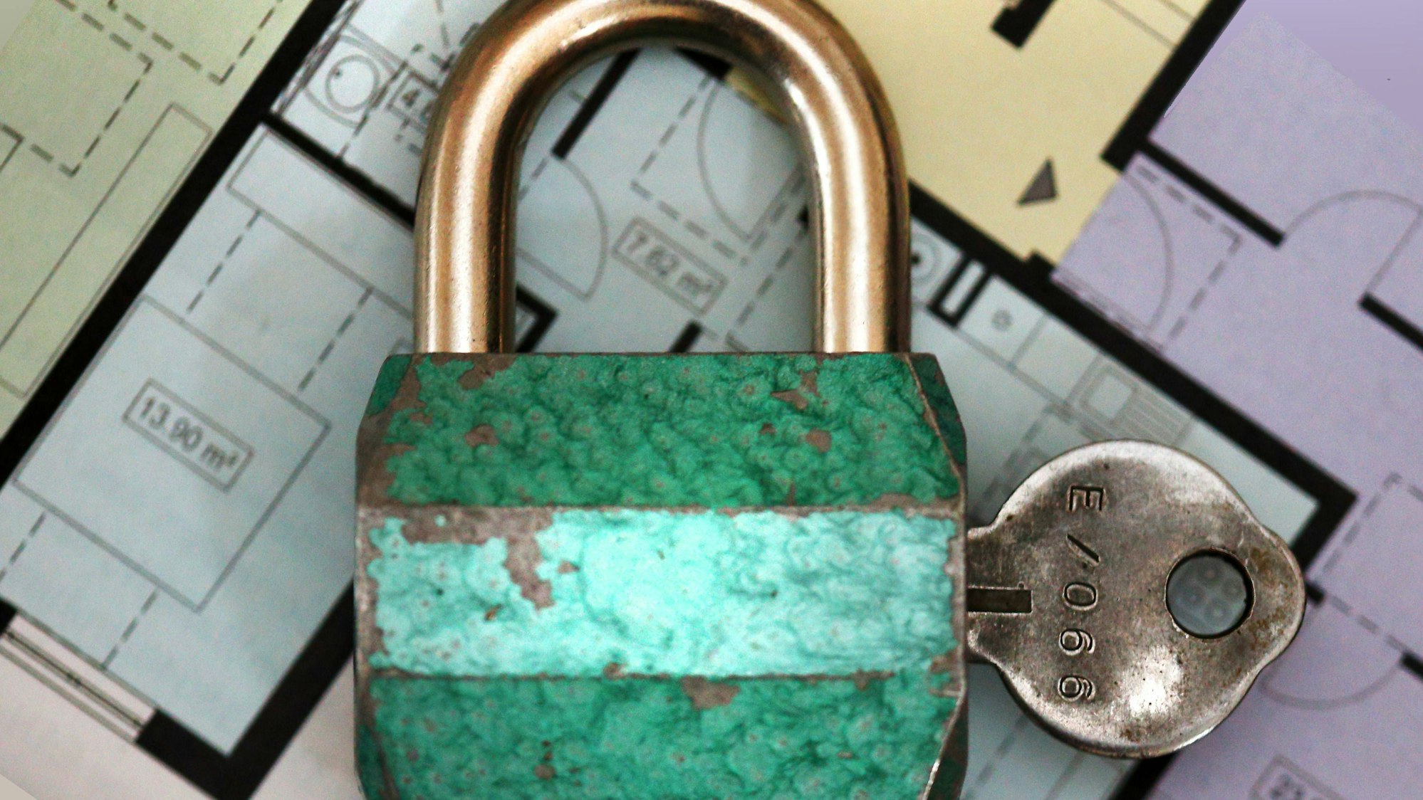Vorhängeschloss und Schlüssel auf Bauplänen