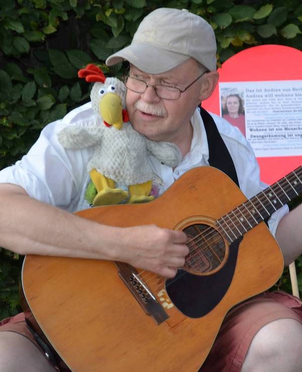 Der beliebte Kölner Straßenmusiker „Fliege“ spielt Gitarre