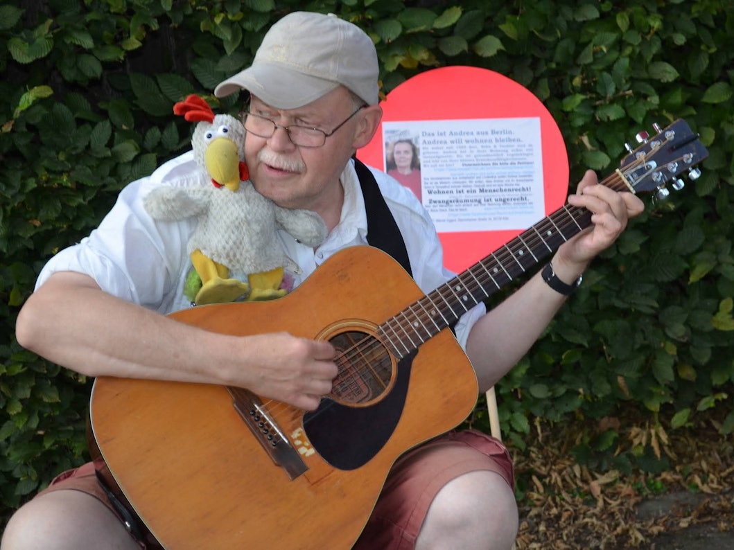 Der beliebte Kölner Straßenmusiker „Fliege“ spielt Gitarre