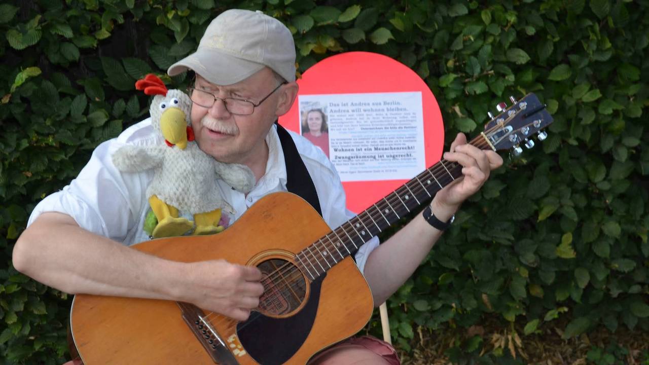 Der beliebte Kölner Straßenmusiker „Fliege“ spielt Gitarre