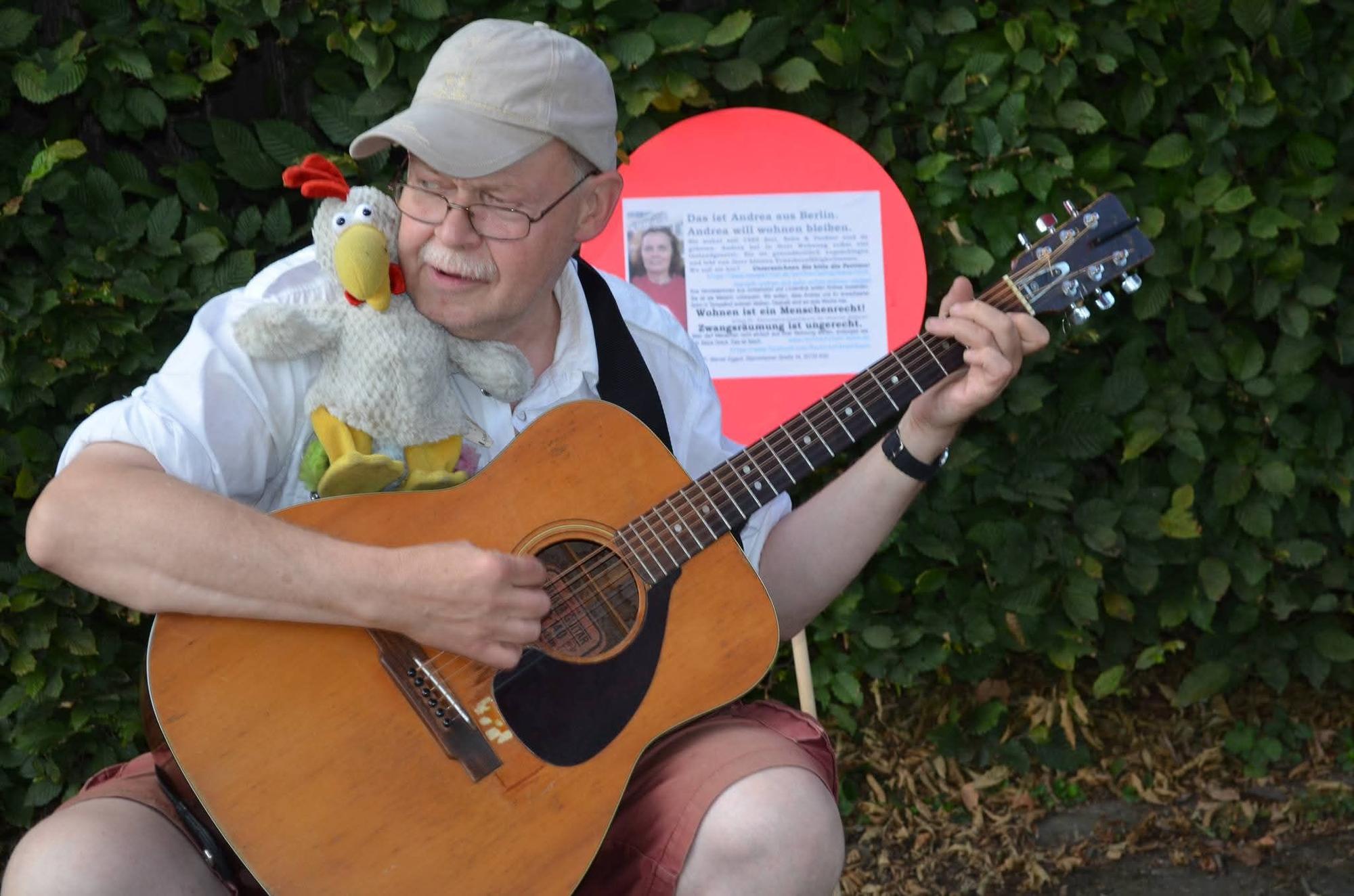 Der beliebte Kölner Straßenmusiker „Fliege“ spielt Gitarre