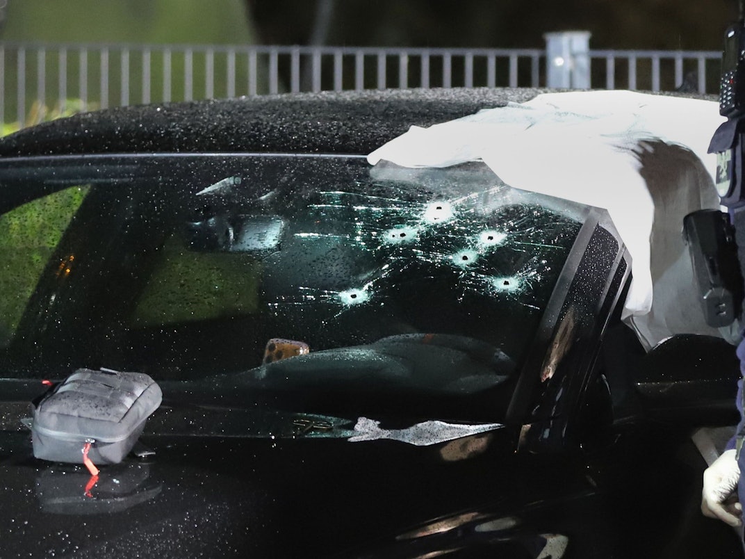 Einsatzkräfte der Polizei an dem durch Schüsse getroffenen Pkw. Ein Mann wurde durch die Windschutzscheibe angeschossen und lebensgefährlich verletzt.