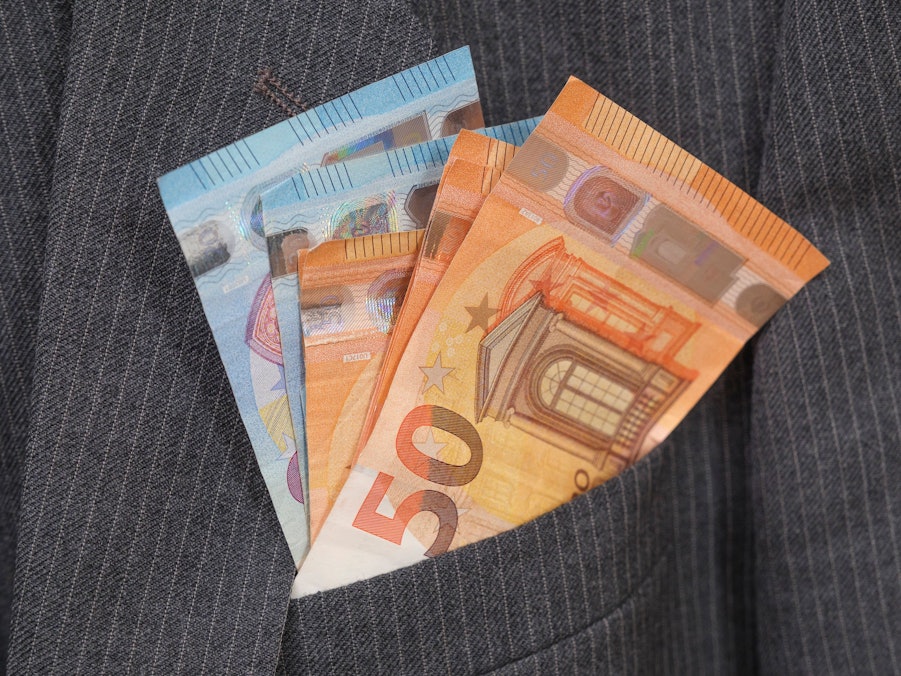 Euro-Banknoten schauen aus Anzugtasche