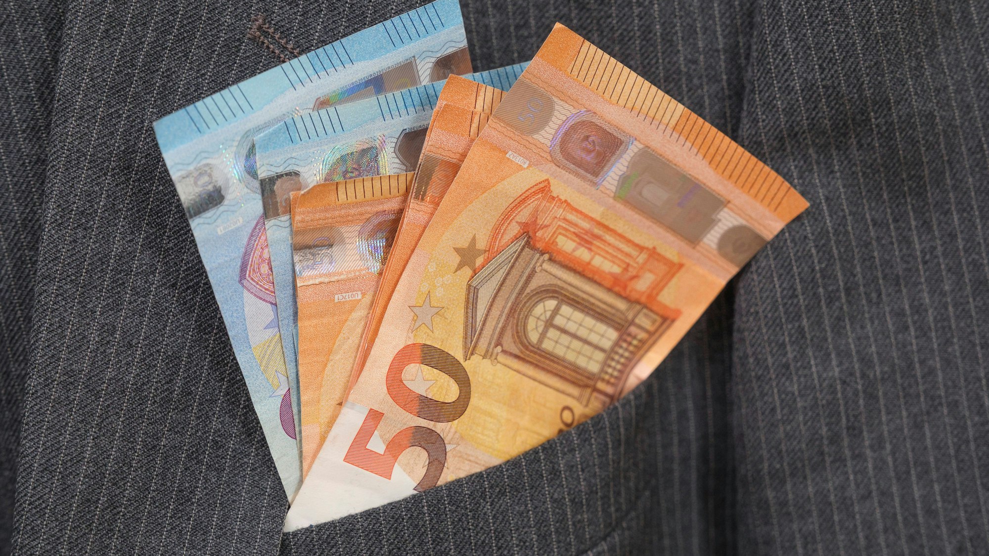 Euro-Banknoten schauen aus Anzugtasche