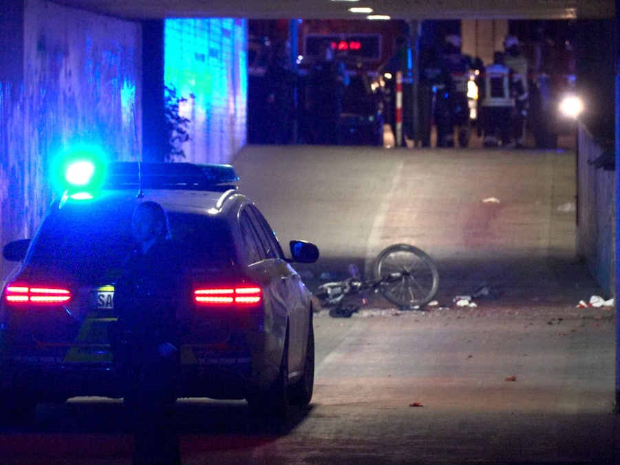 Polizei und Feuerwehr sind an einer Unterführung im Einsatz. Nach einem lauten Knall hat die Polizei unter einer Fußgängerbrücke im Saarland einen Toten und mehrere Schwerverletzte gefunden.