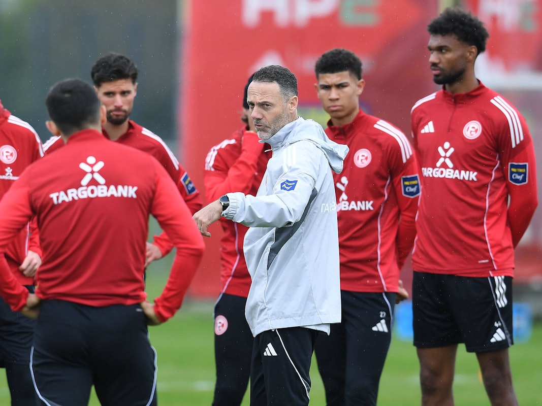 Alexander Ende gibt den Profis von Fortuna Düsseldorf auf dem Trainingsplatz Anweisungen.