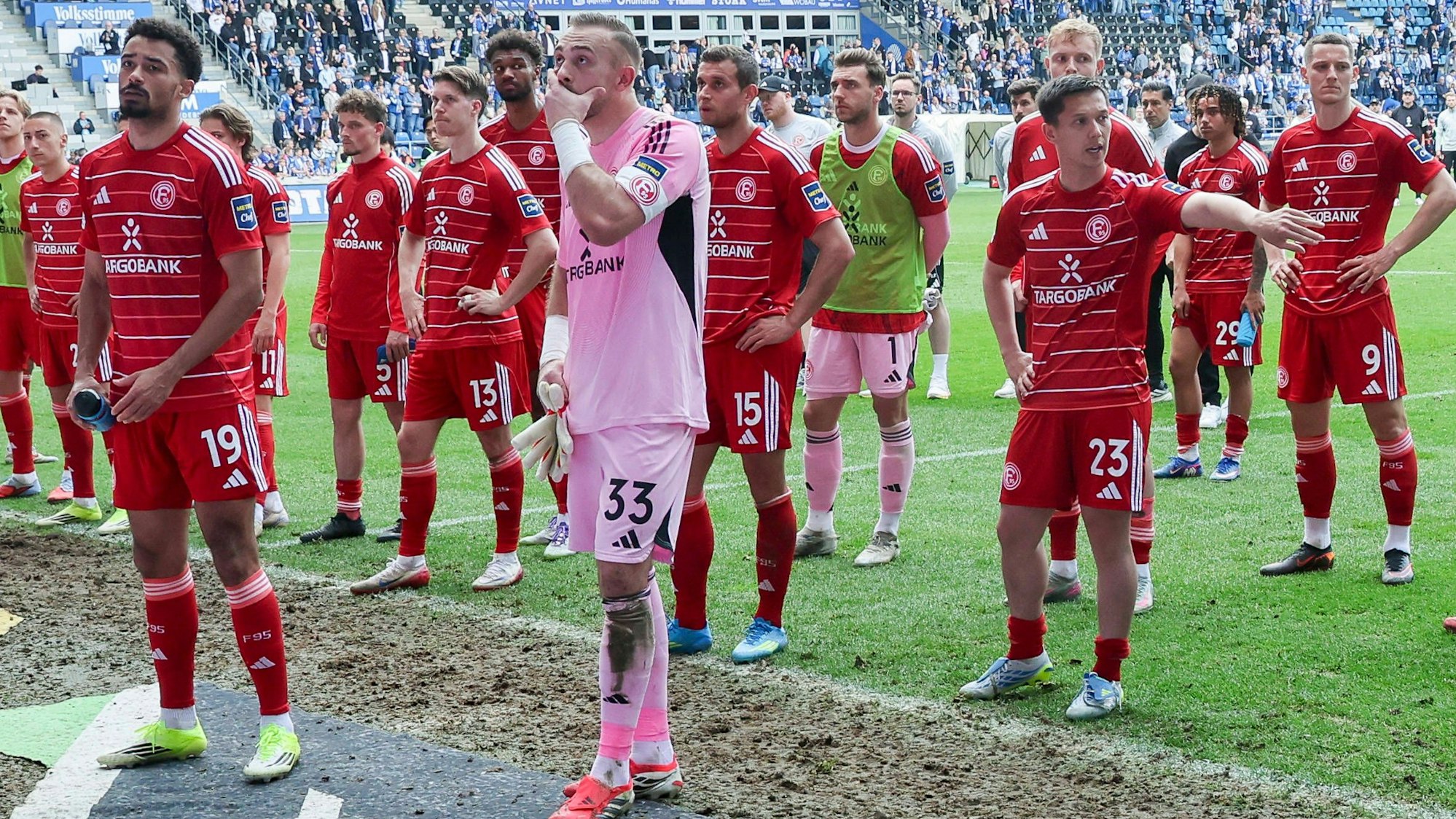 Die Spieler von Fortuna Düsseldorf stehen nach dem Spiel in Magdeburg enttäuscht vor dem Fanblock.