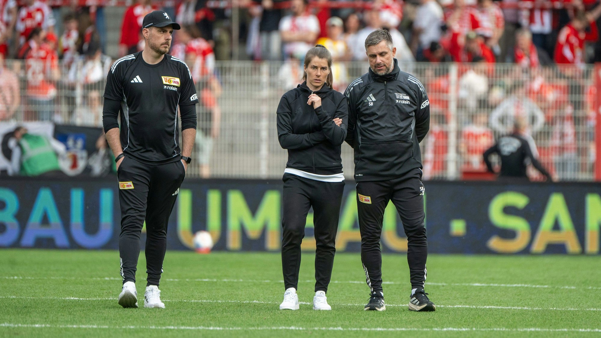 Trainerin Marie-Louise Eta (m.) mit ihren Co-Trainern Andreas Kerwin und Sebastian Bönig schauen nach der Niederlage gegen Wolfsburg frustriert.