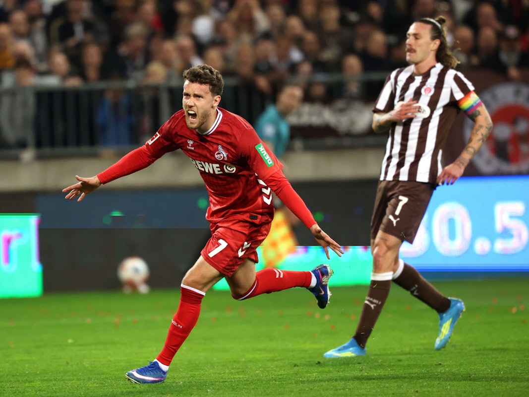 Luca Waldschmidt (l, 1. FC Köln) jubelt nach einem 1:1 Ausgleichstreffer, während Jackson Irvine (FC. St. Pauli) zusieht.